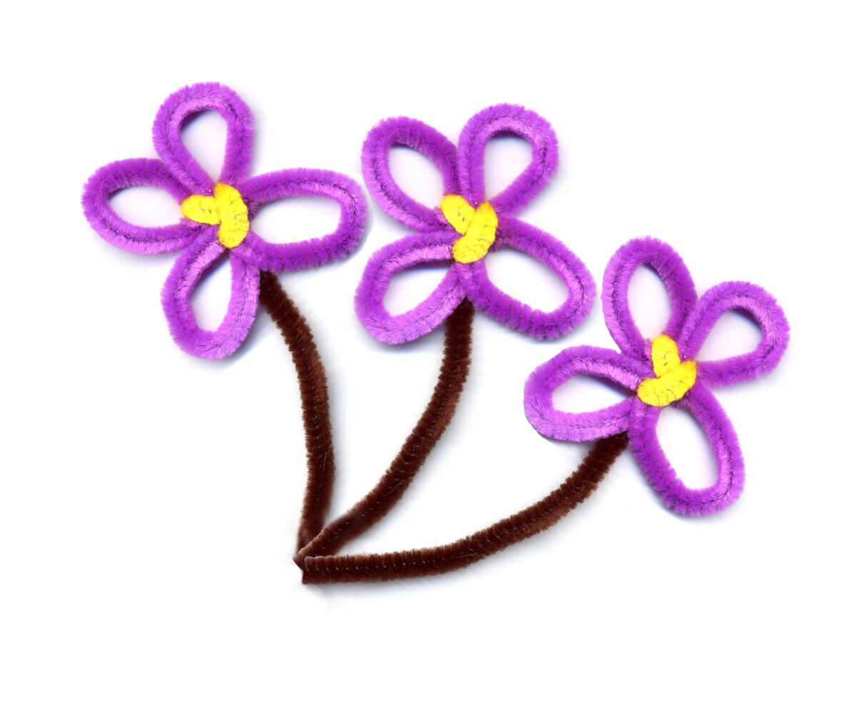 Purple pipe cleaner flowers with yellow centers and brown stems. 