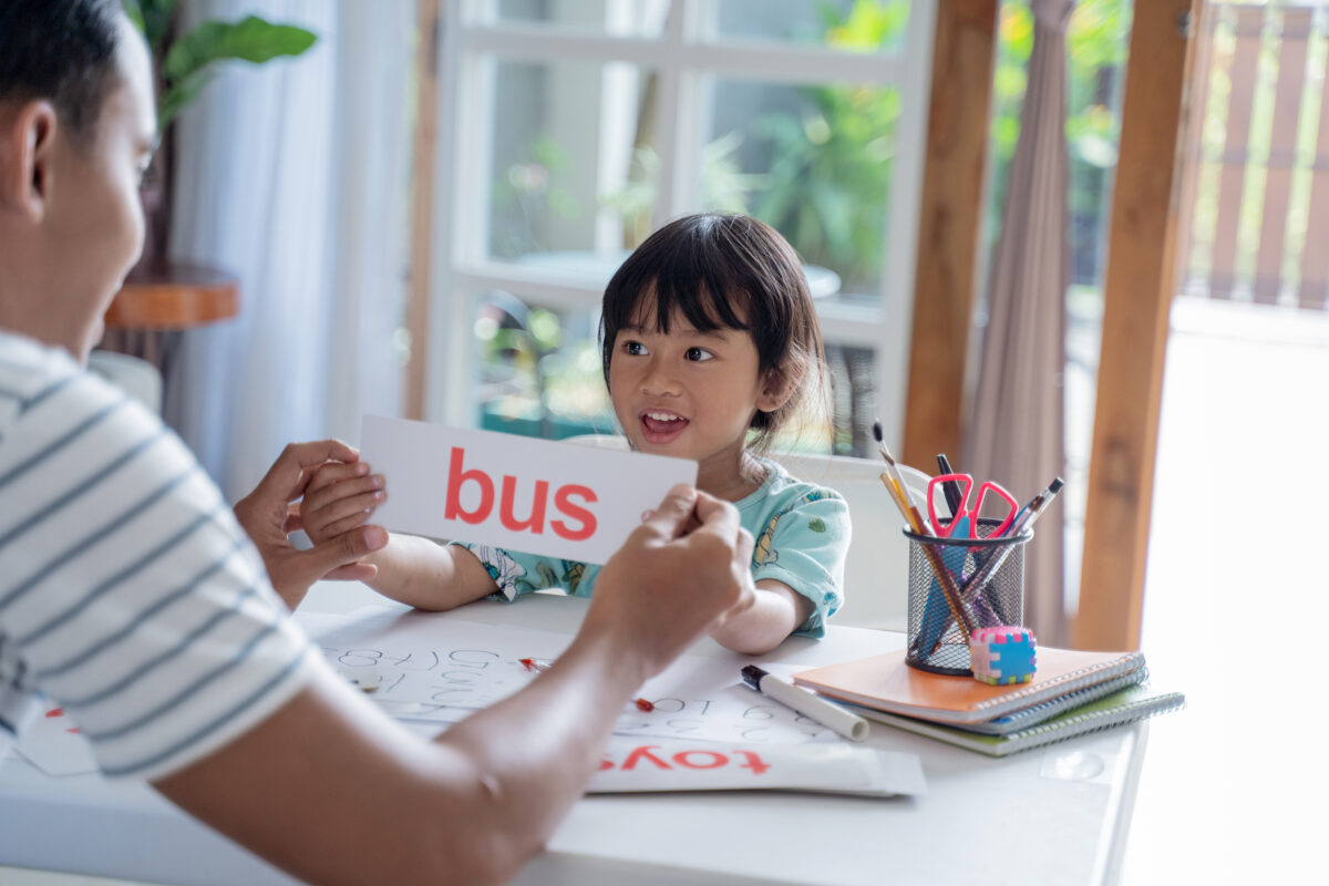 Father and daughter working together with flashcards. 