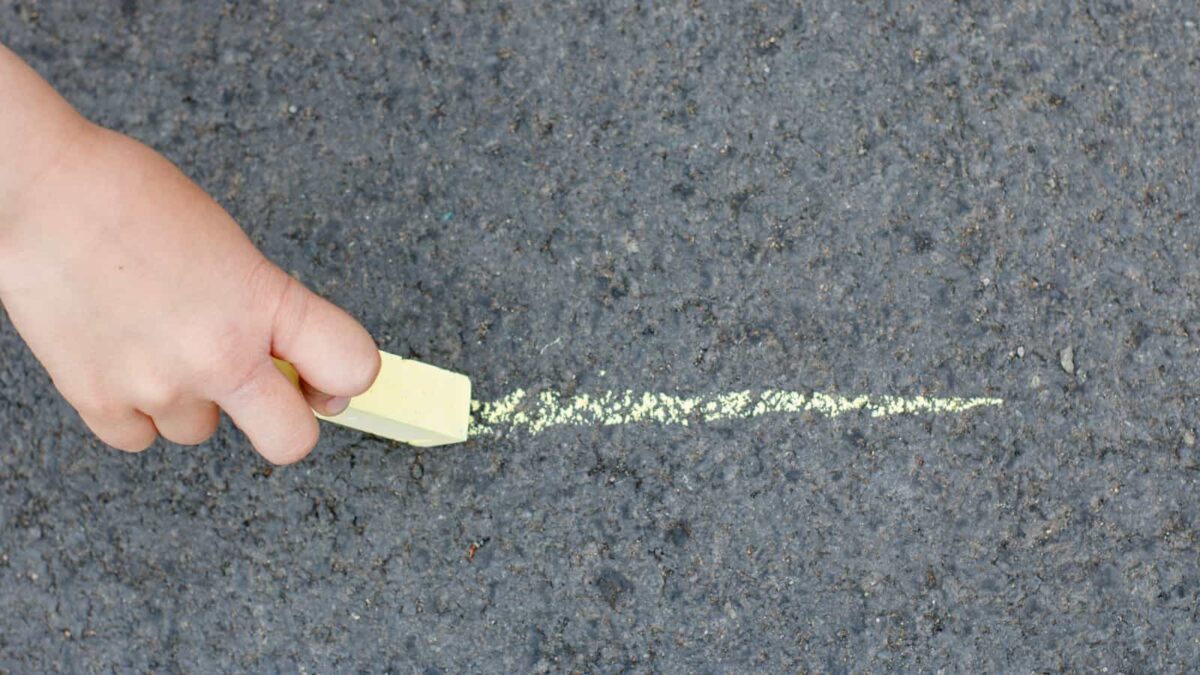 Child's hand drawing with sidewalk chalk. 