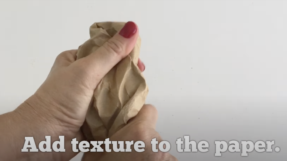 Hands crinkling paper to add texture. 