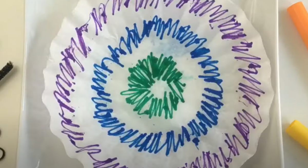 A coffee filter colored with markers in rings of color. 