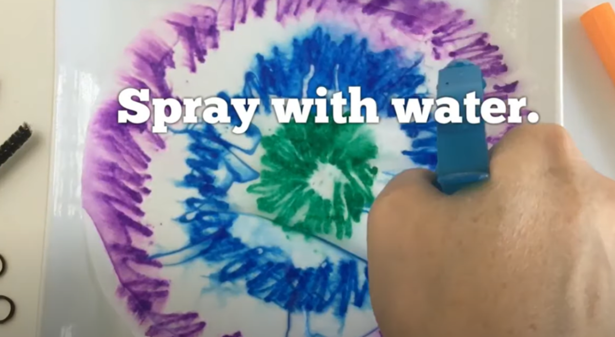 A colored coffee filter being sprayed with water. 