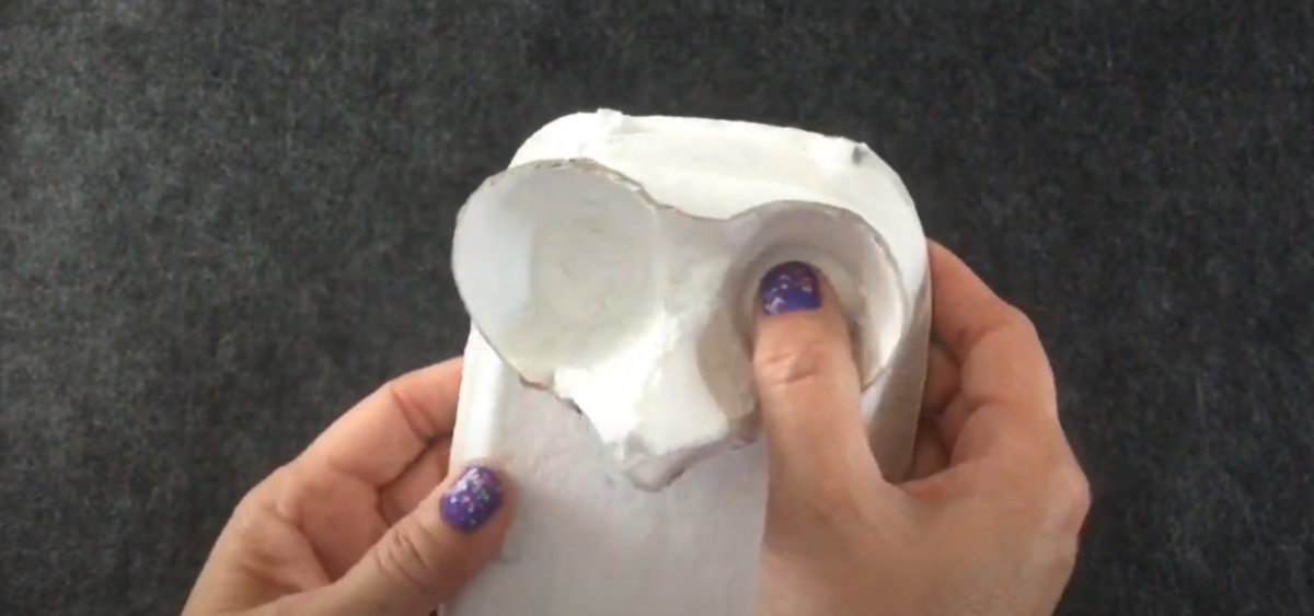 Gluing two pieces of an egg carton together for a Thanksgiving turkey craft. 