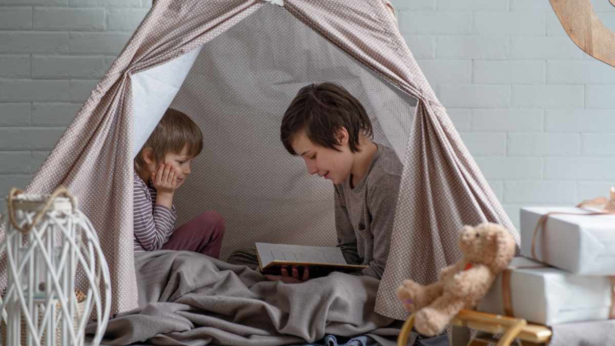 Boys reading in a cozy tent. 