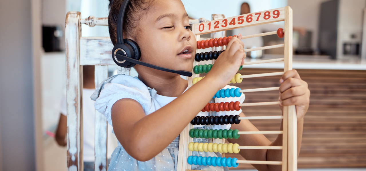 Young girl using and abacus while wearing headphones. 