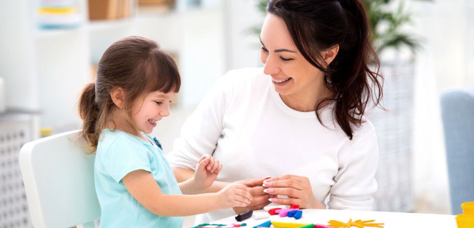 A mother and daughter playing with playdough together. 