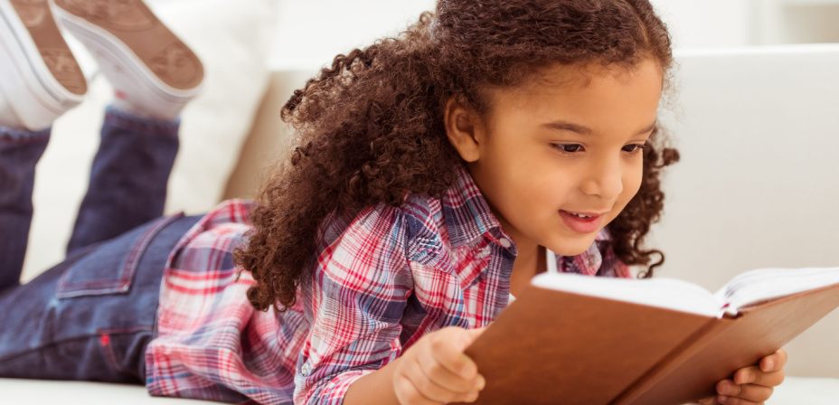 Little girl learning to read by practicing phonics. 