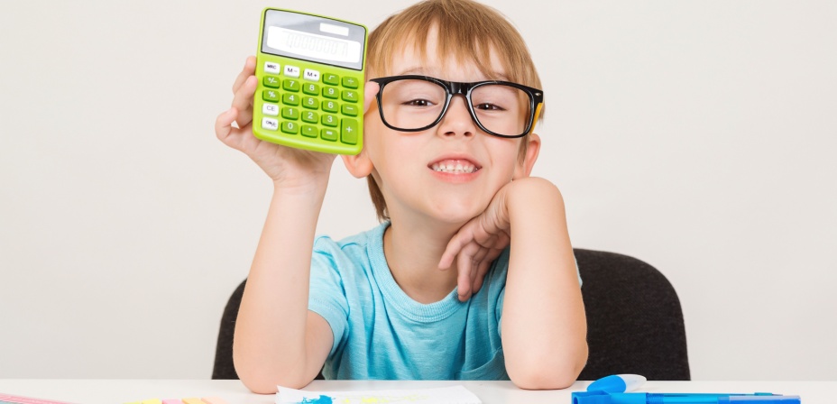 A child holding a green calculator with a smile on his face. 