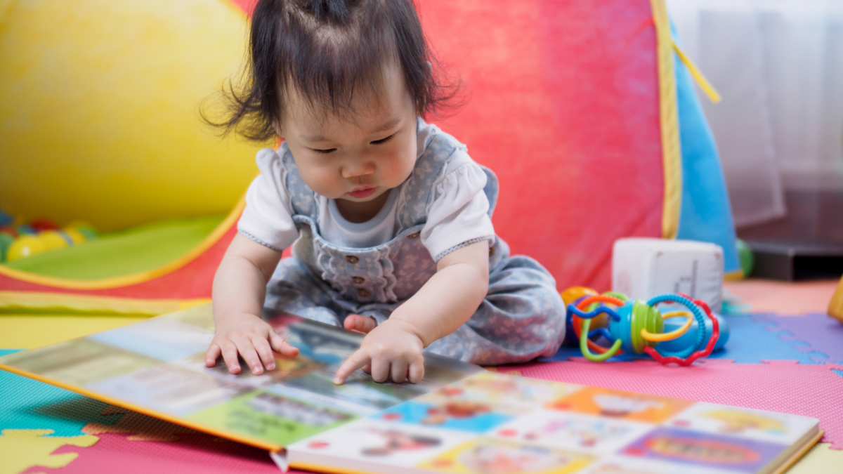 Young baby looking at a book. 