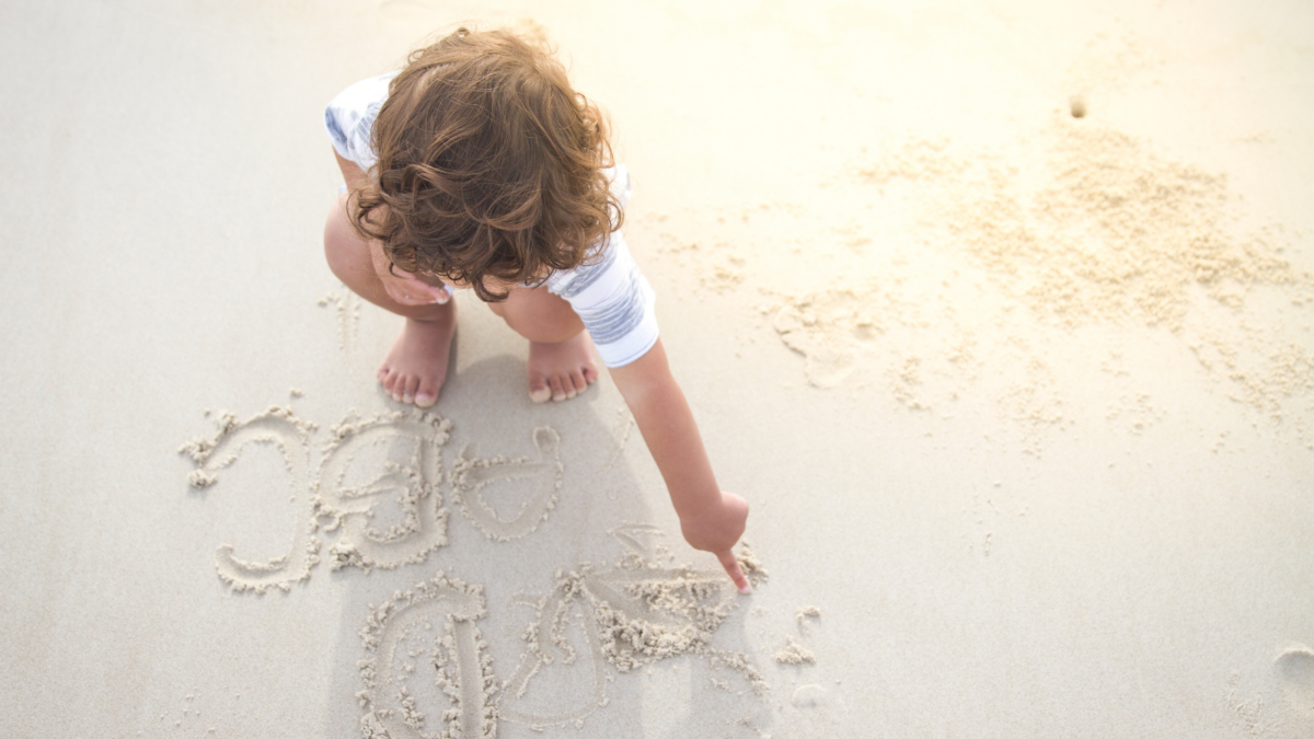 Writing letters in the sand. 