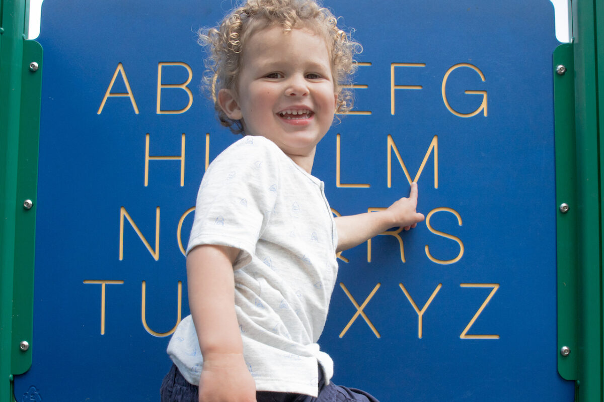 Child pointing to letters. 