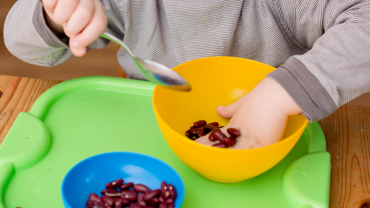 A child playing with beans. 