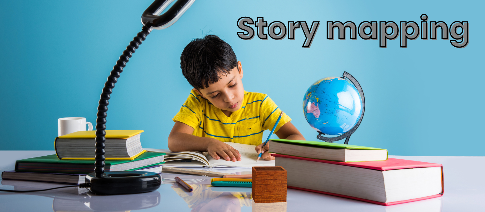 A young boy writing in a notebook on a desk covered in books. 