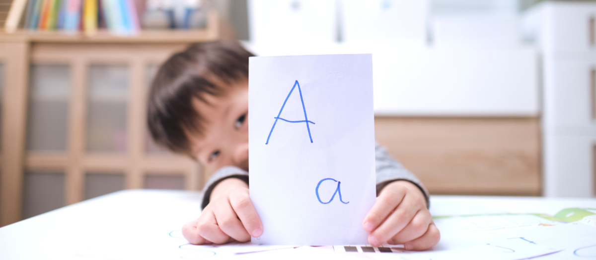 Boy holding letter card. 