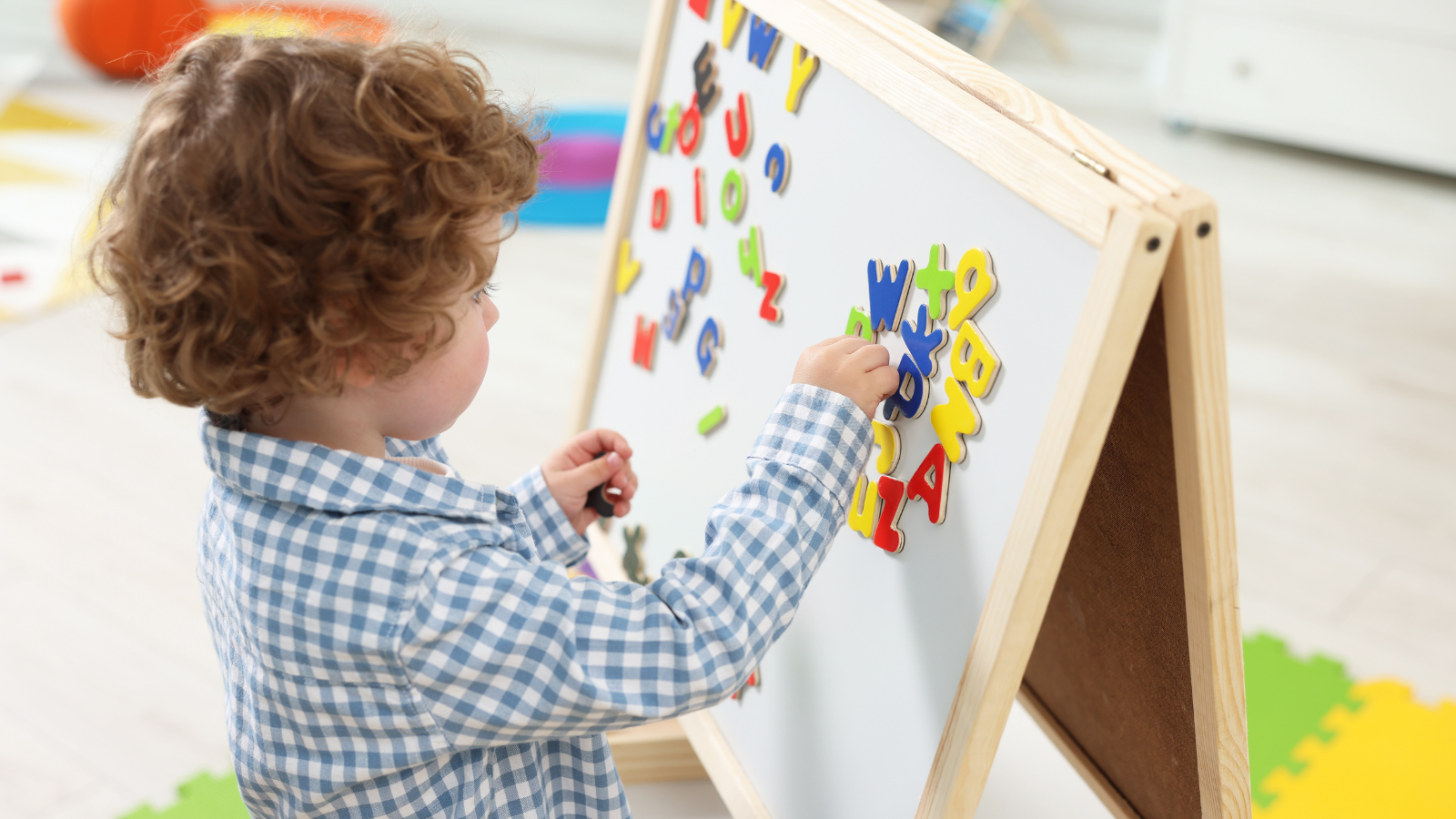 Boy playing with magnetic letters. 