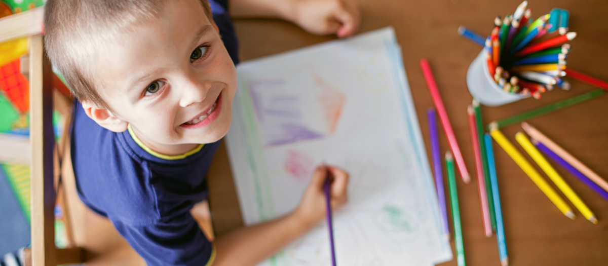 Young preschool boy drawing a picture of a story he just read. 