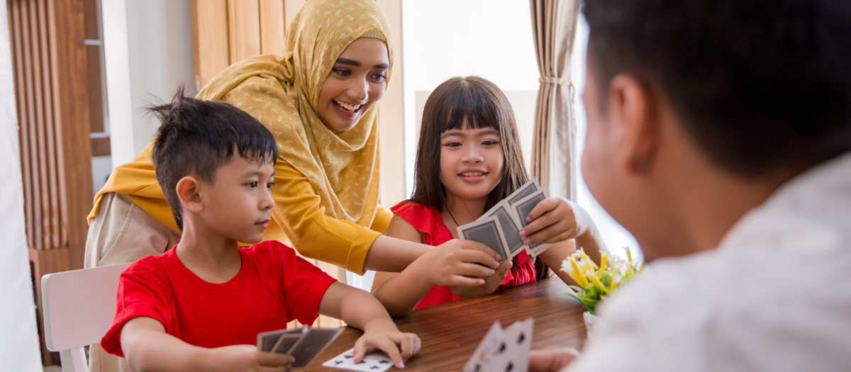 A family playing go fish together with playing cards. 