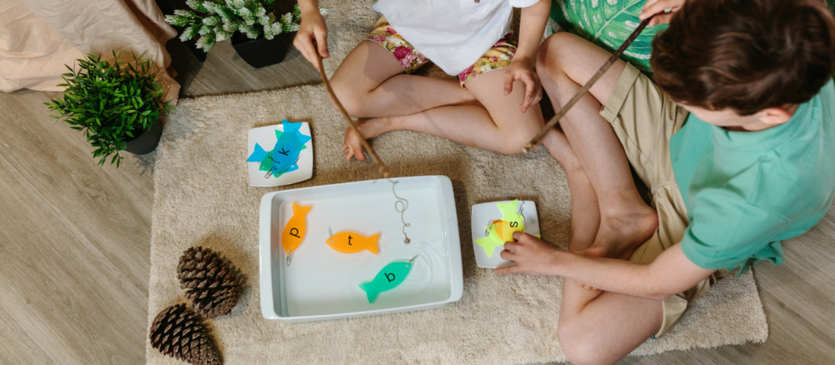 Kids playing a fishing for letters game. 