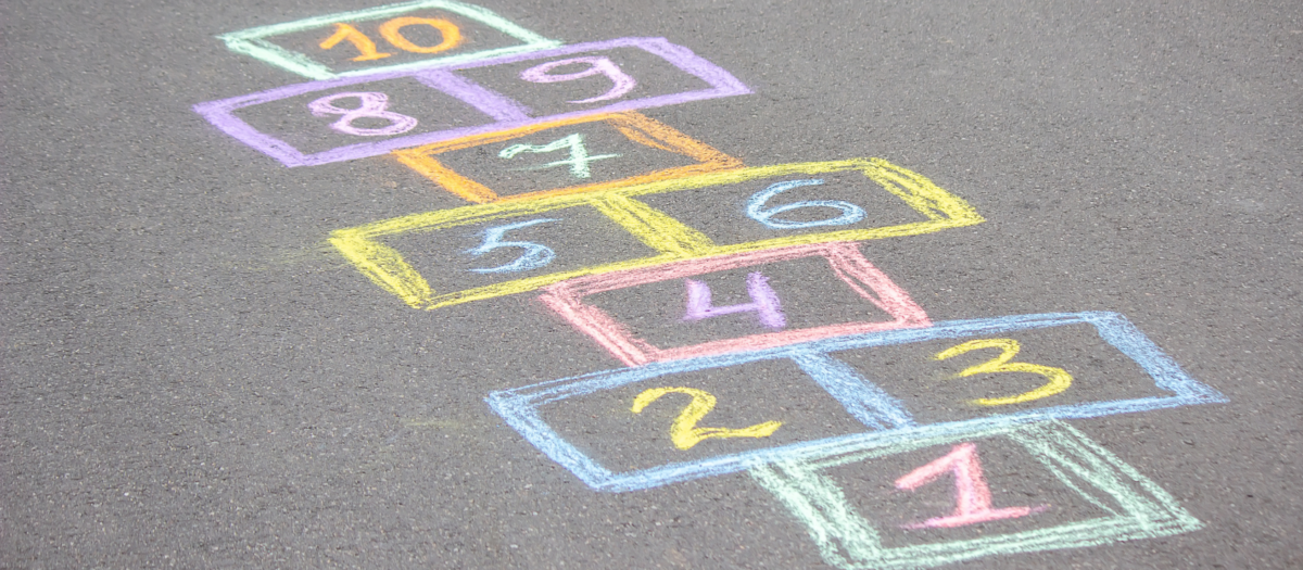 Colorful hopscotch numbers on pavement. 