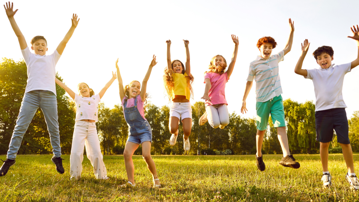 Children standing in a row and jumping. 