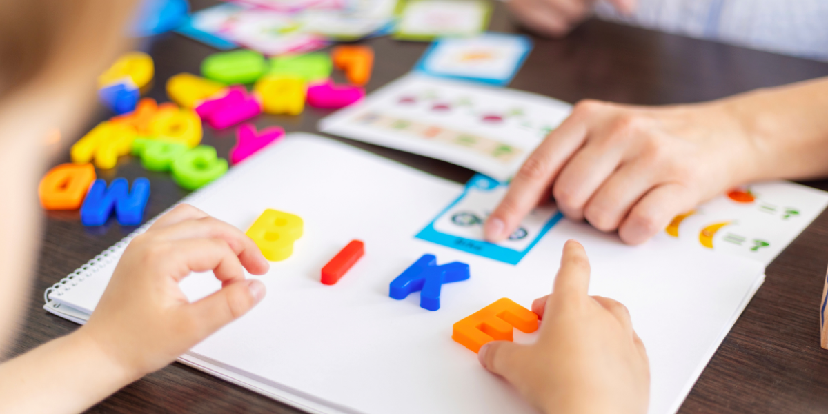 Child playing with colorful letters learning how to spell words. 