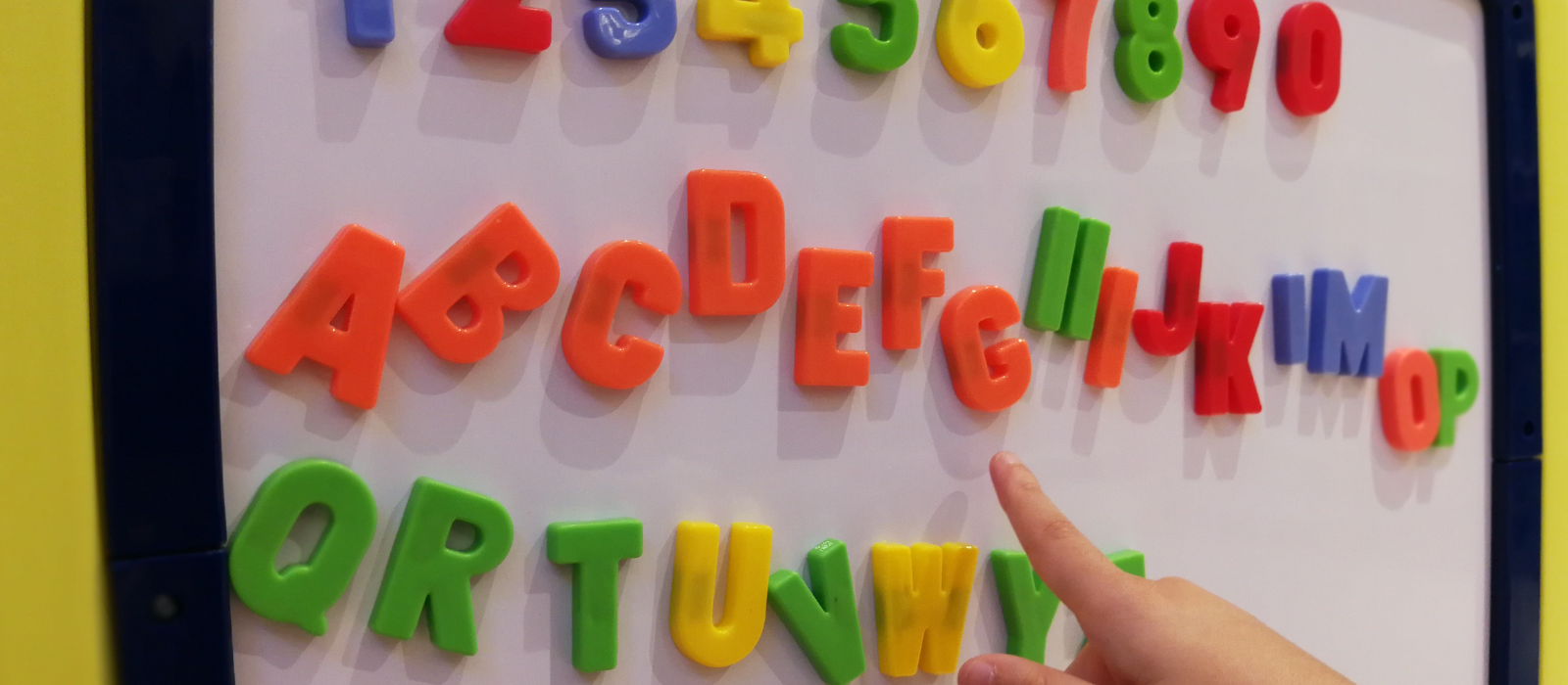 Colorful letter magnets on a white board. 