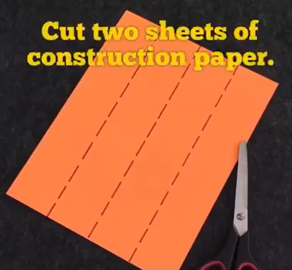 Cutting orange constructions paper into strips. 