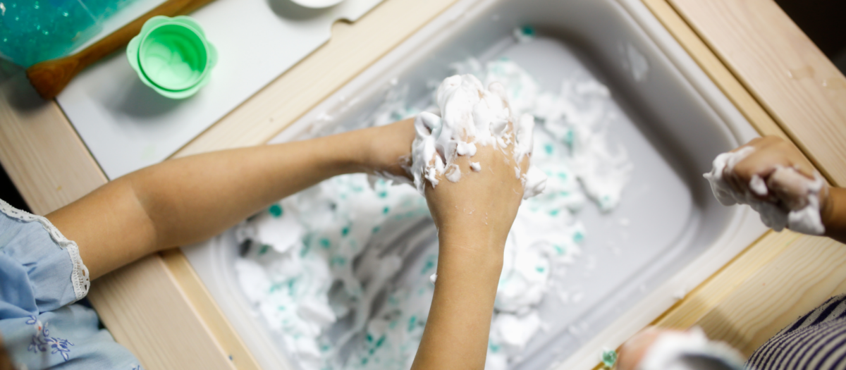 Young child playing with shaving cream. 