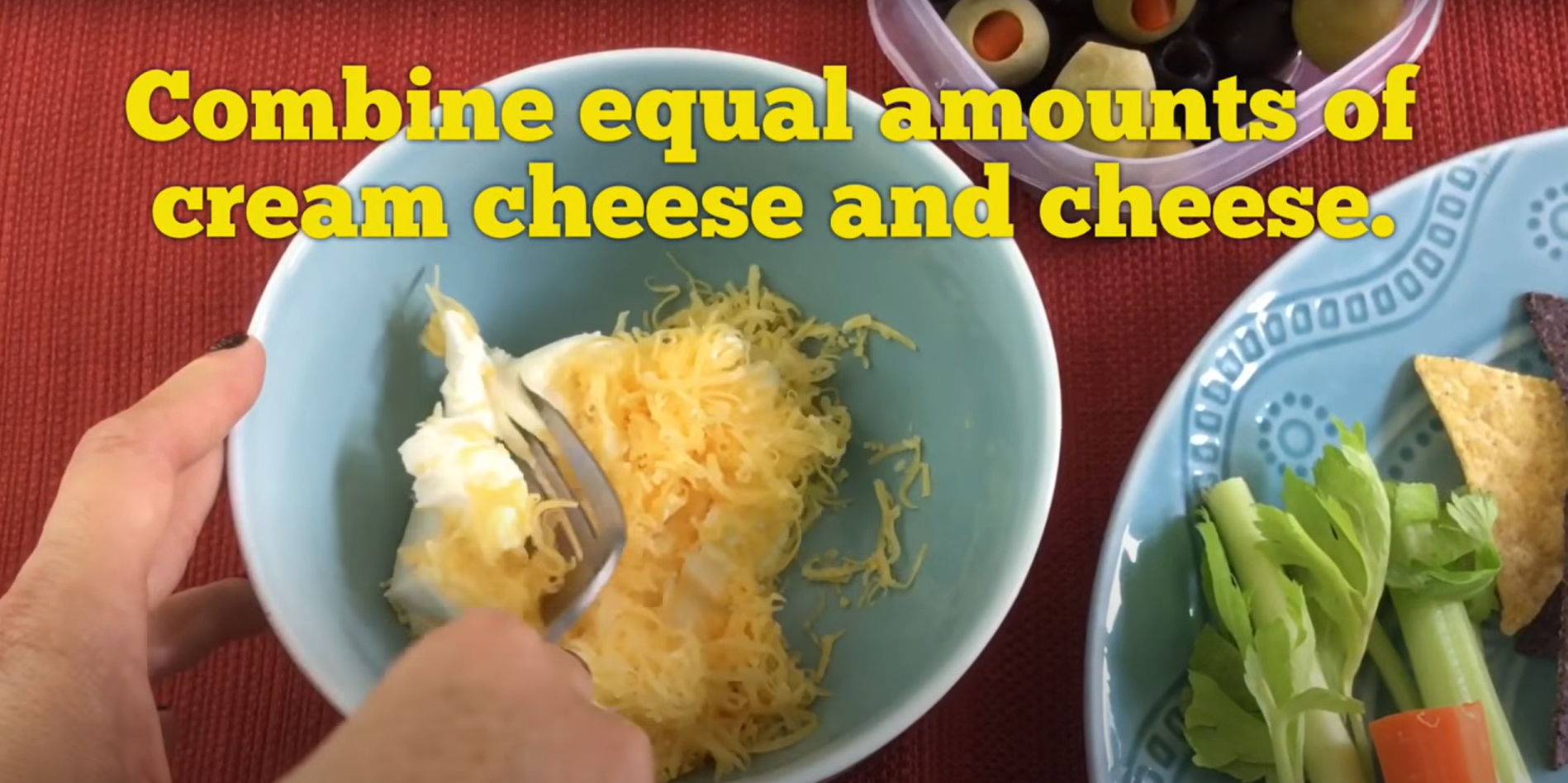 Mixing cream cheese and cheddar cheese together in a bowl. 