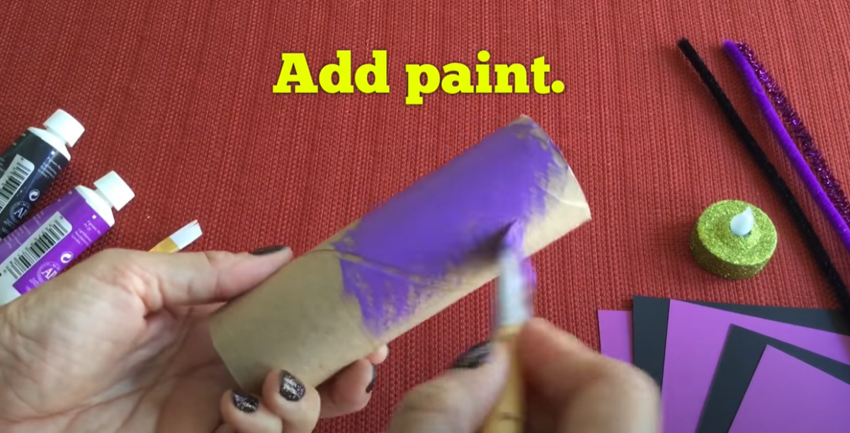 Painting the cardboard tube purple for the Halloween bat craft. 