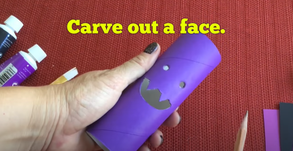 Carve out the face of your purple tube bat craft. 