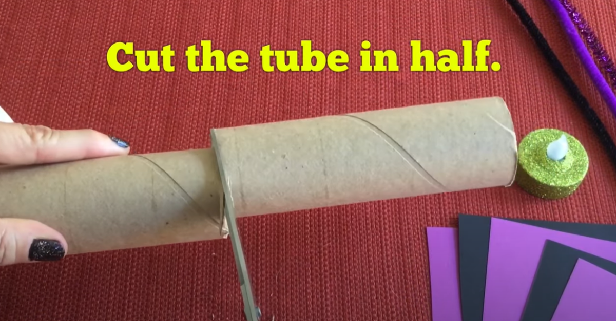 Cutting a cardboard tube in half. 