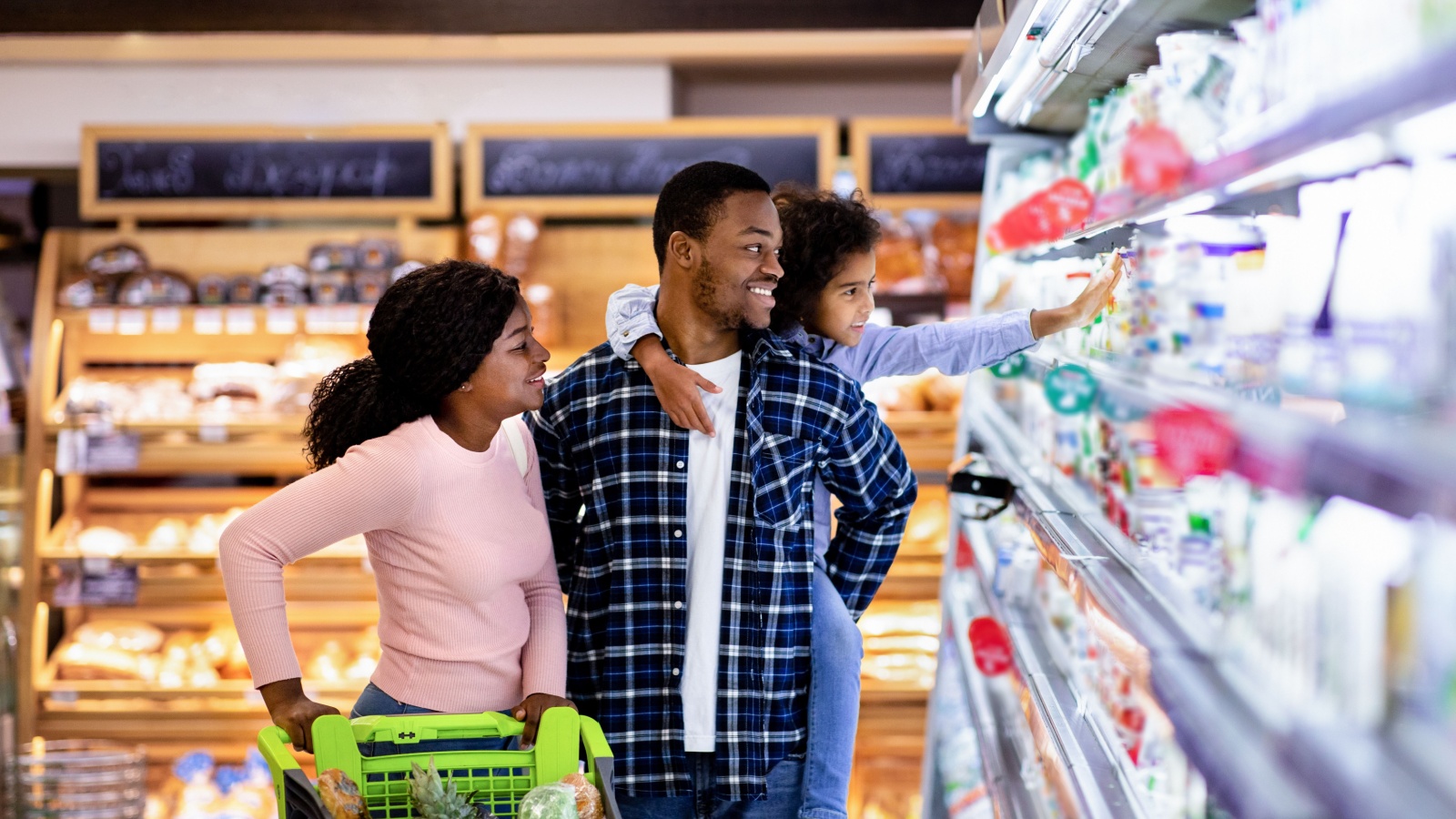 Parents and child grocery shopping together. 