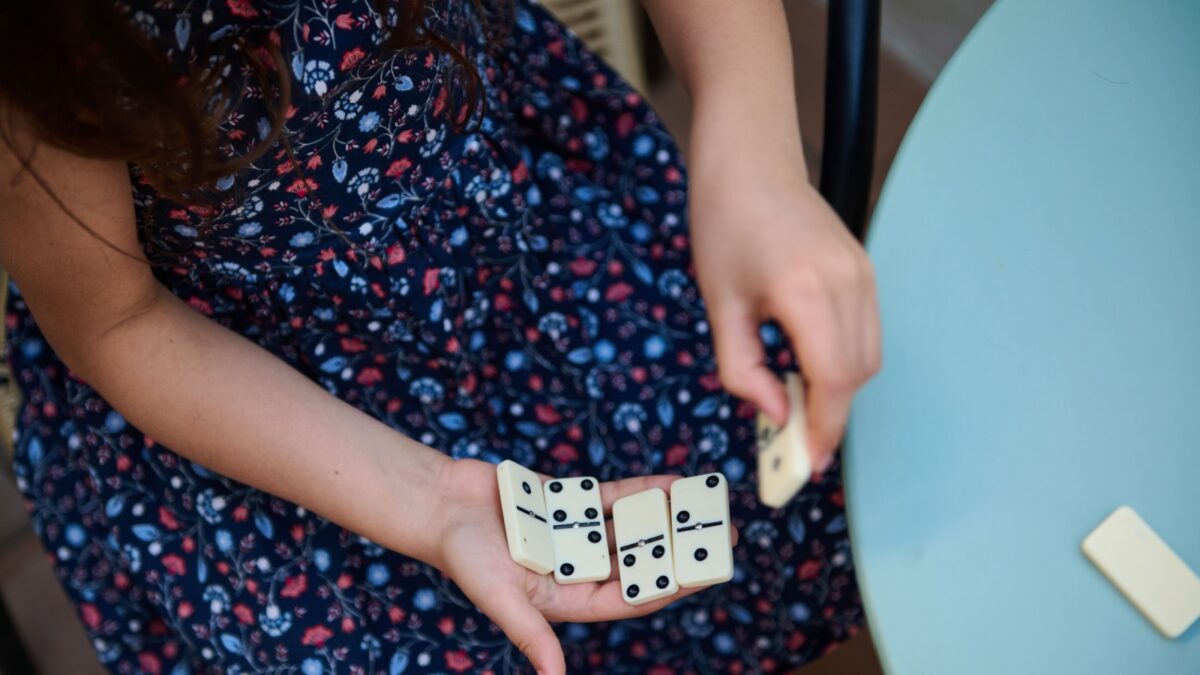 A child holding dominos and adding them up. 