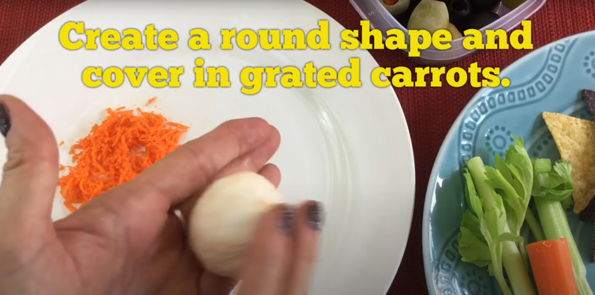 Roll the cheeses into a ball to get ready to cover in grated carrots. 