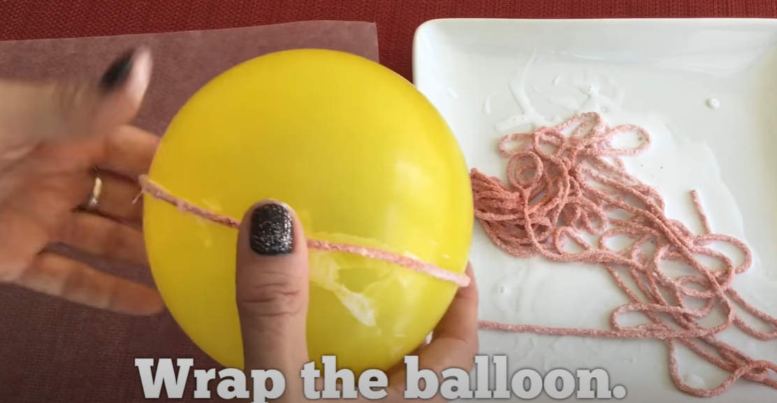 Wrapping a balloon with glue soaked yarn for a fun fall craft. 