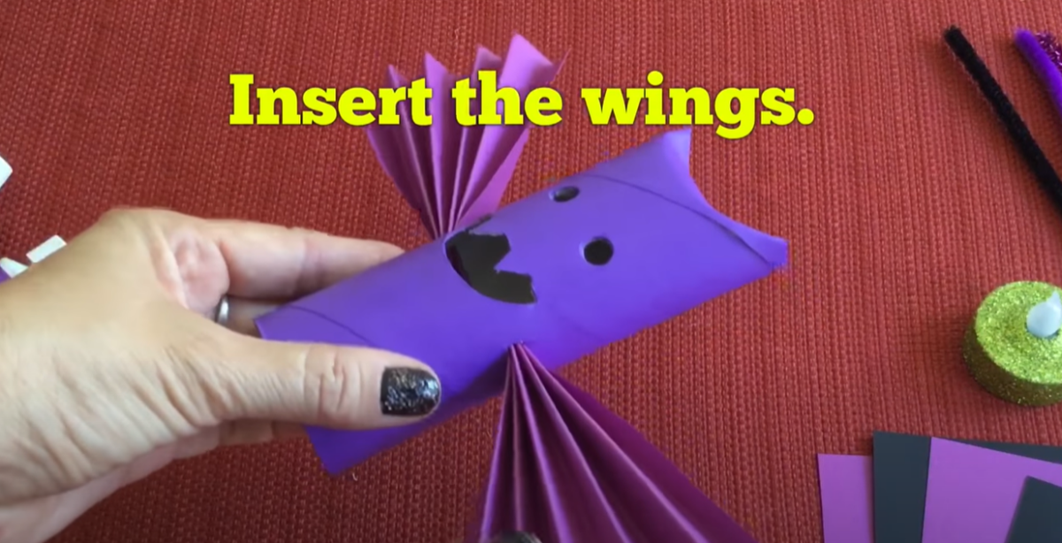 Inserting the folded paper in the purple tube. 