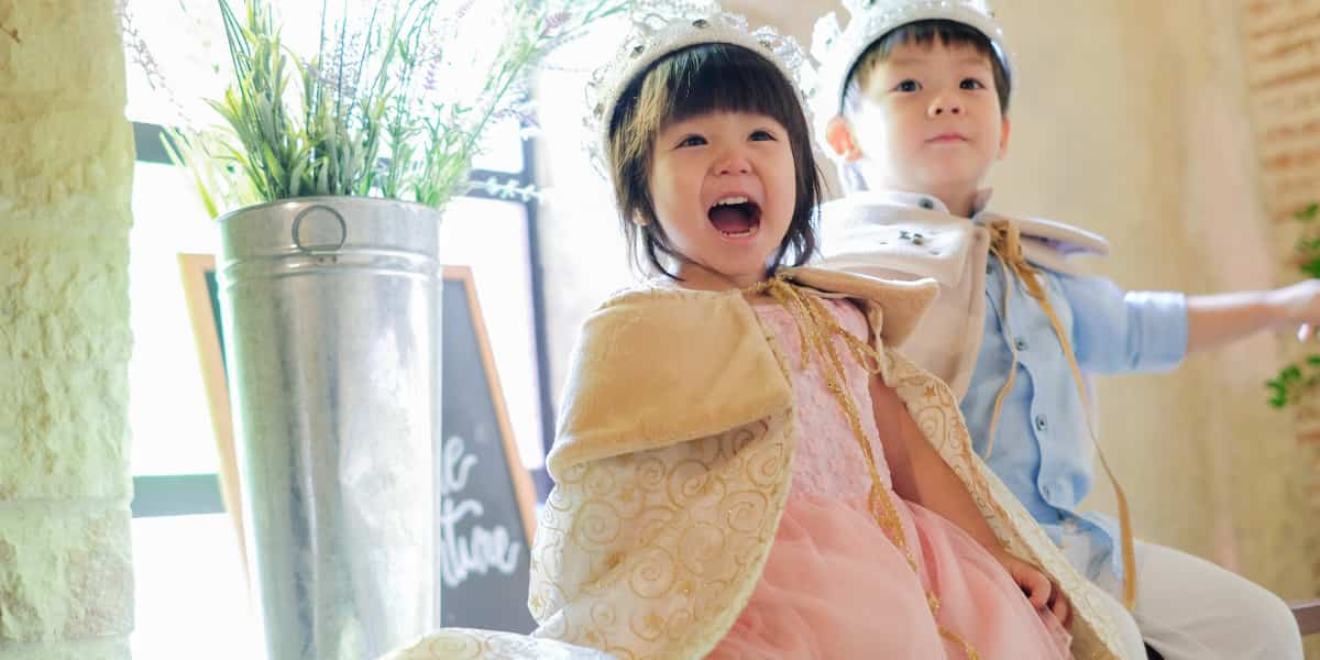 Two young children dressed up as royalty to act out their favorite fairy tale. 