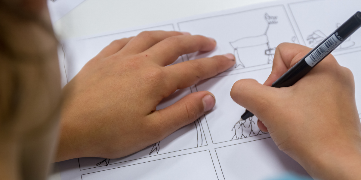 Young child drawing pictures on a storyboard. 