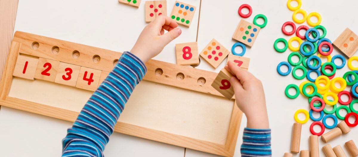 Child playing with number tiles to learn addition. 