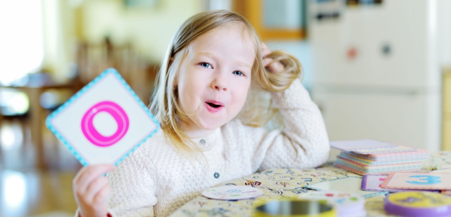 Child holding a flashcard. 