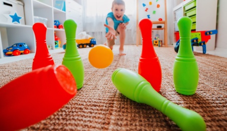 Child playing with plastic bowling pins. 