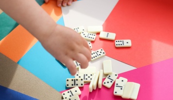 Child playing with dominos. 