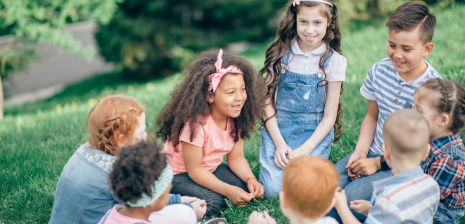 Kids sitting in a circle having fun laughing together. 