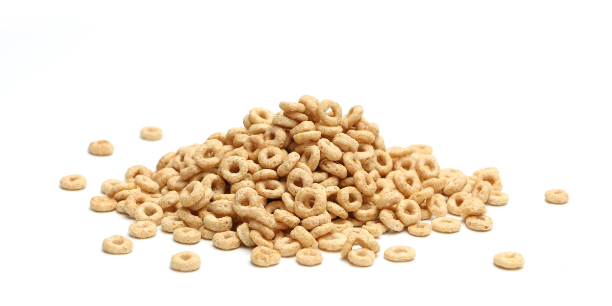 A pile of cheerios cereal on a white background. 