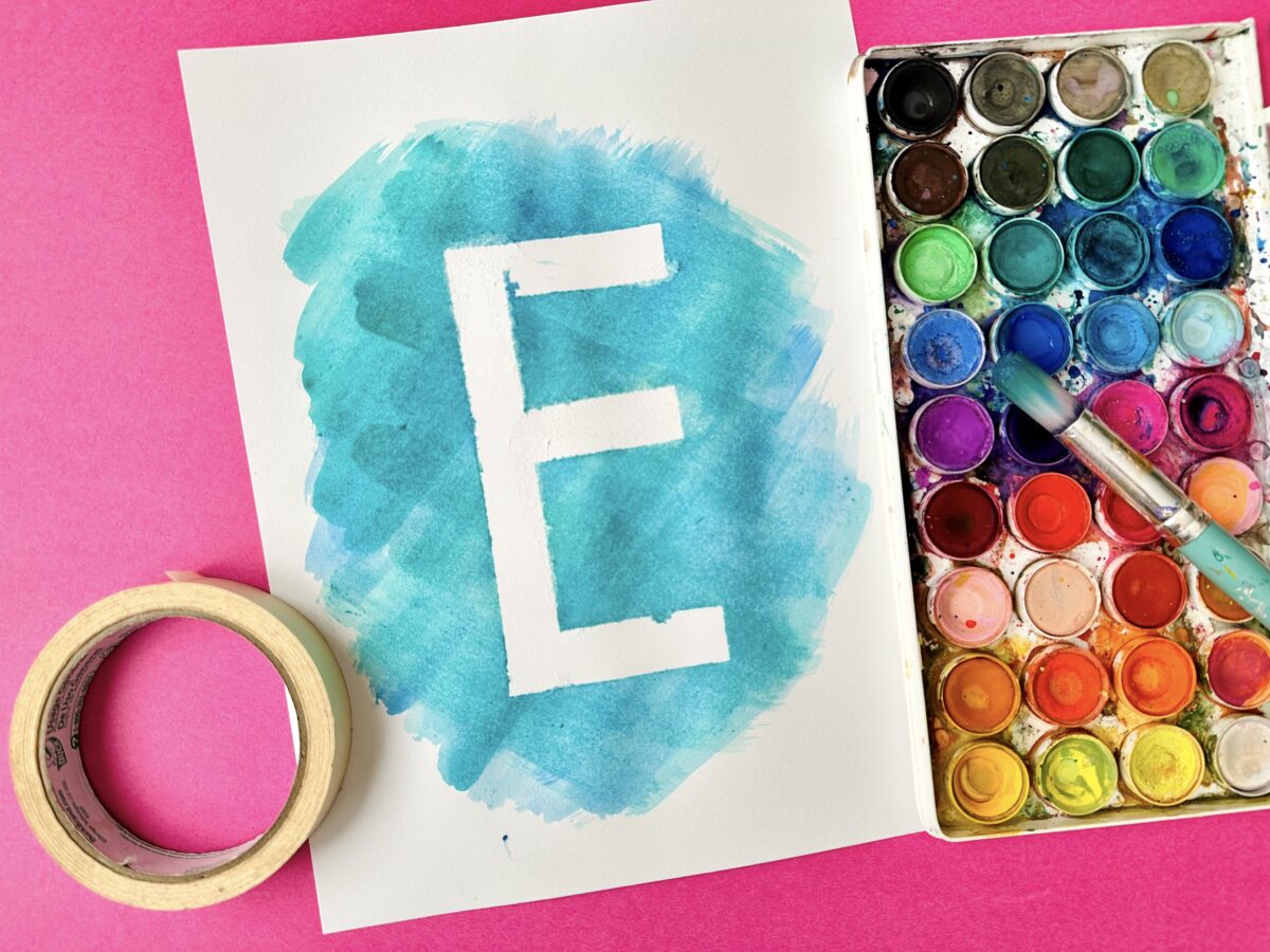 An outline made from the letter e by taping the letter e on paper then painting over it with watercolor then removing the tape. 