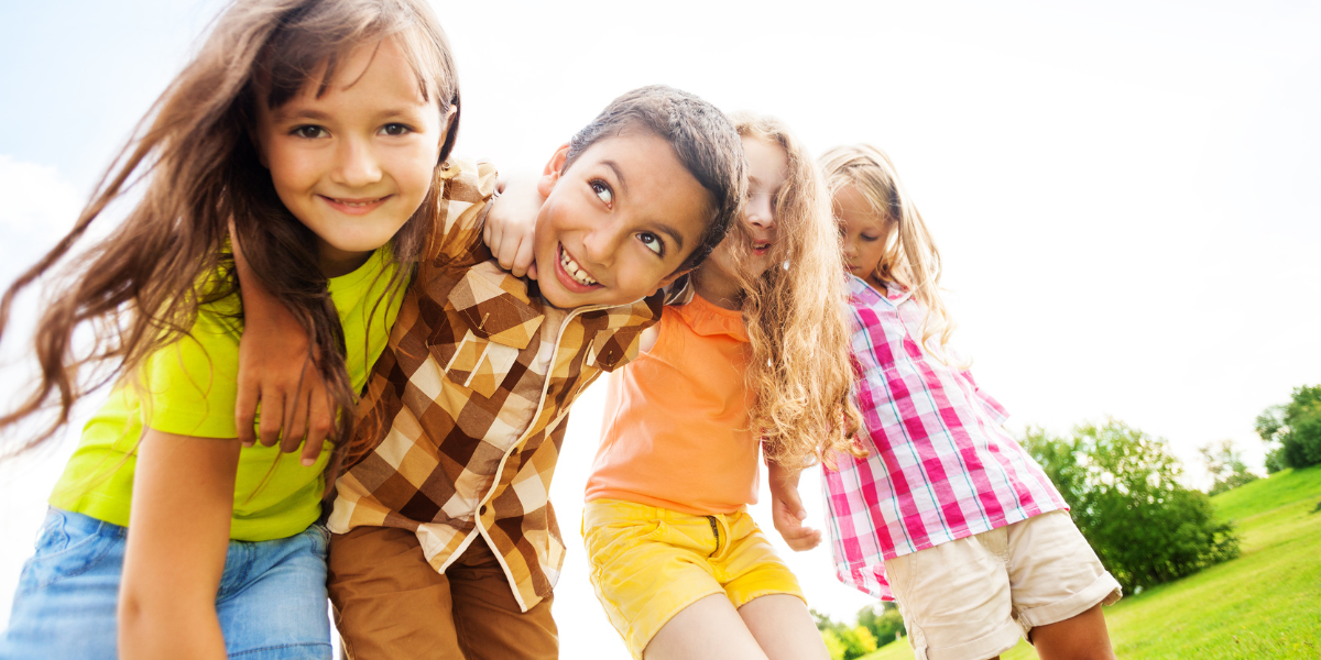 Kids in a line smiling. 