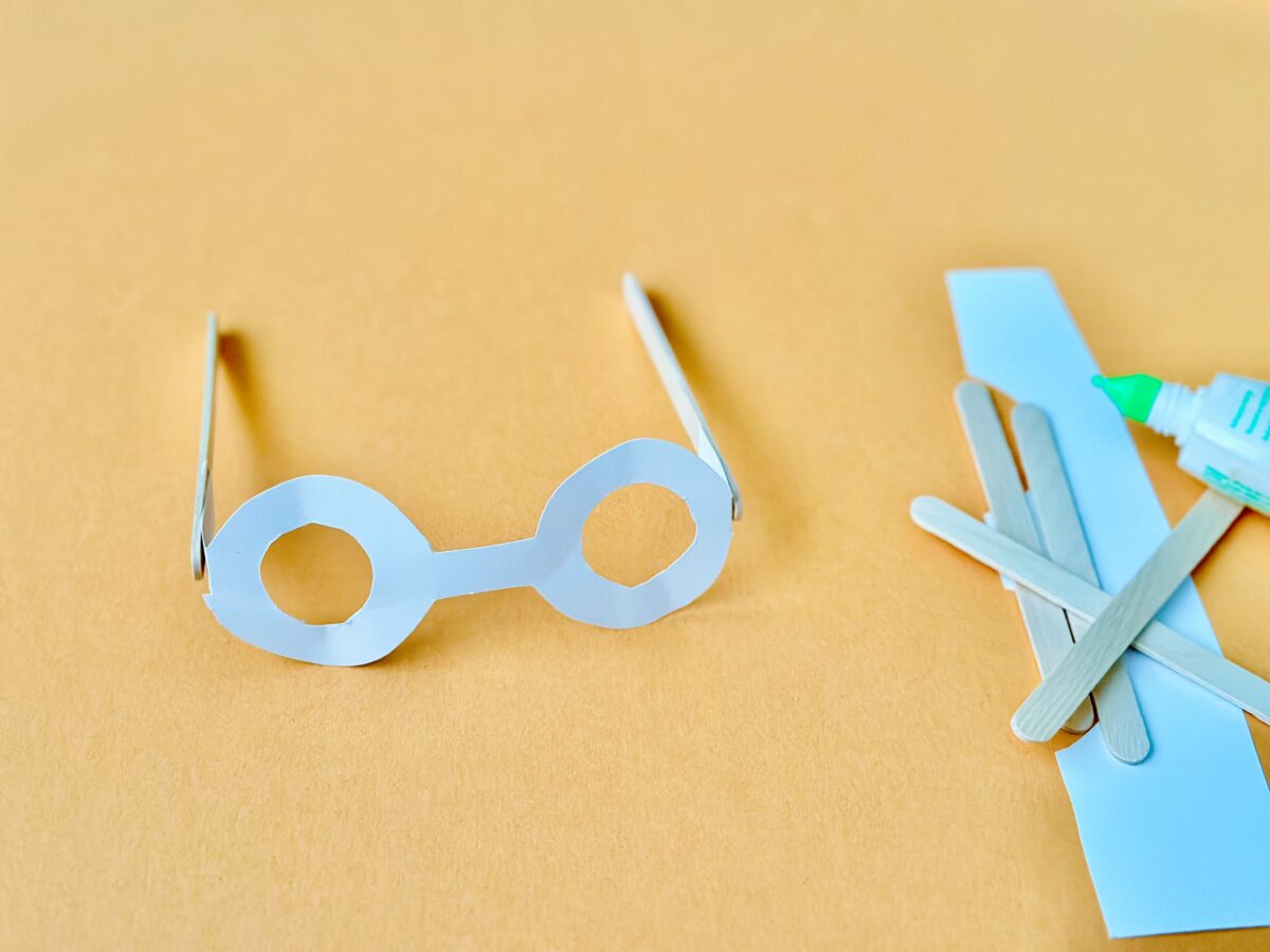 A DIY pair of glasses made from construction paper and popsicle sticks. Letter g craft from ABCmouse.com