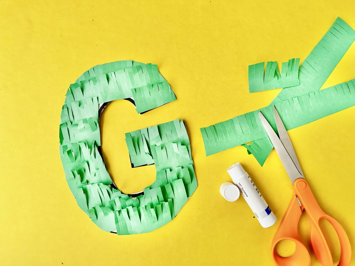 A large letter G with green construction paper fringe meant to look like grass covering it. Letter g craft from ABCmouse.com