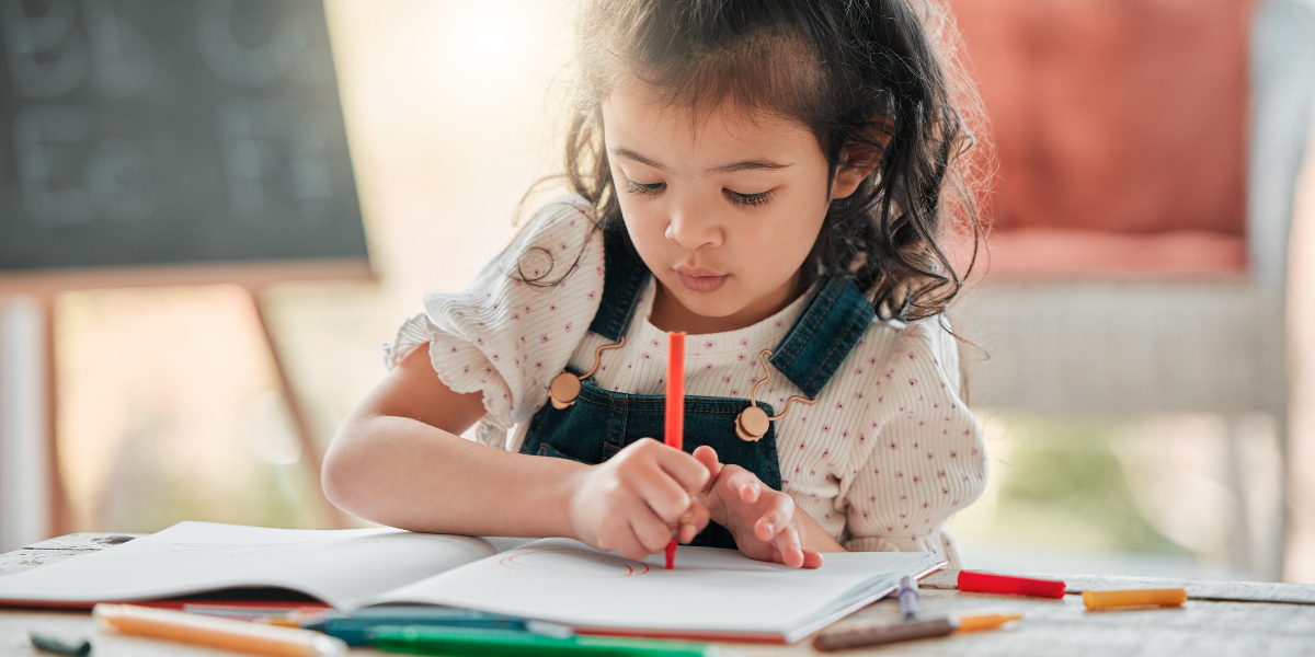 Cute little girl drawing in a notebook. 